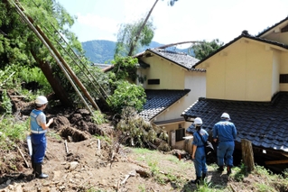 裏山の土砂がなだれ込んだ民家の被害状況を調べる朝来市や兵庫県の職員＝２１日午前、香美町村岡区和田