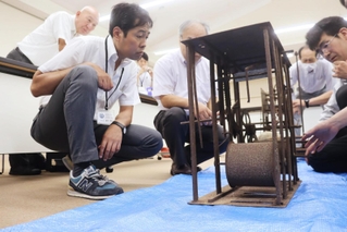 時計の金属部品に目を凝らす関係者ら＝豊岡市出石振興局
