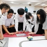 ネーティブ教員やＡＬＴらとロボットプログラミングを学ぶ高校生たち＝豊岡高校