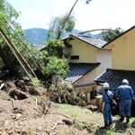 裏山の土砂がなだれ込んだ民家の被害状況を調べる朝来市や兵庫県の職員＝２１日午前、香美町村岡区和田