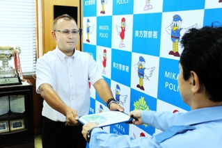 鯉田茂樹署長（手前）からのじぎく賞を受け取った奥谷康忠さん＝美方署