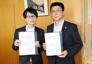 協定書を持つ兵庫豊岡店の山内顕仁ストアマネジャー（左）と、関貫久仁郎市長＝豊岡市役所