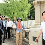 北但大震災当時の様子などの説明を聞きながら、まち歩きをする斎藤元彦知事（右）＝城崎温泉街