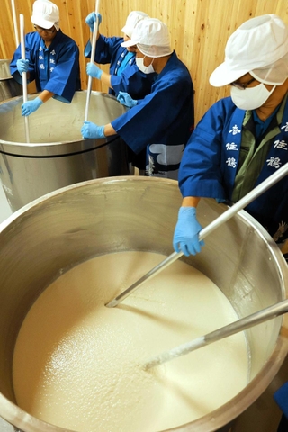 酒母室のタンクを櫂（かい）でかき混ぜる蔵人たち＝香住鶴
