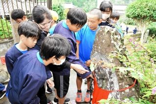 家族が弥兵衛の無罪放免を願ったとされる地蔵を見学する児童たち＝朝来市和田山町野村