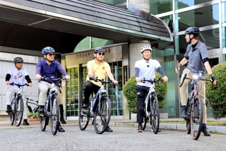 電動自転車に乗って地域巡りをスタートさせる斎藤元彦知事（右から２人目）ら＝生野マインホール