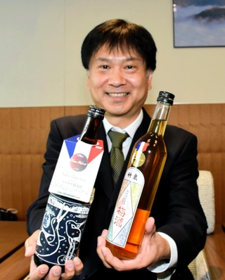 蔵マスターで入賞した竹泉の「生酛純米　幸の鳥　兵庫錦」と「純米山田錦　梅酒」、田治米博貴社長＝朝来市役所