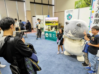 読み聞かせ会後、家族連れと記念撮影するマル＝コウノトリ但馬空港