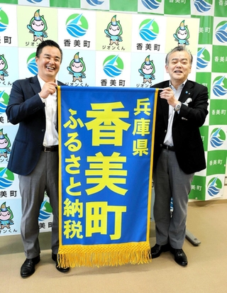 ふるさと納税をＰＲする懸賞旗を掲げる浜上勇人町長（右）と北村浩史室長＝香美町役場