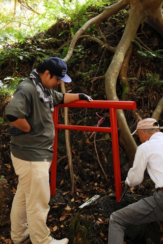 鳥居を設置する龍野コルク工業の社員＝瀞川稲荷神社