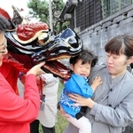 健やかな成長を願って子どもの頭をかむ麒麟獅子＝香美町香住区鎧