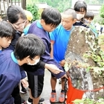 家族が弥兵衛の無罪放免を願ったとされる地蔵を見学する児童たち＝朝来市和田山町野村