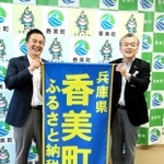 ふるさと納税をＰＲする懸賞旗を掲げる浜上勇人町長（右）と北村浩史室長＝香美町役場