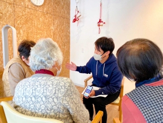 送迎業務の専用システムの使い方を利用者に説明する様子（アンズケア提供）