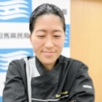 本物の石はどれだ？　軽石を模した「スコリア　ブラウニー」を手にする久保和代さん＝豊岡総合庁舎