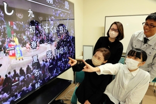 懸賞旗の映り具合をチェックするふるさと納税推進室の職員＝香美町役場