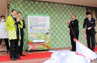 「兵庫県認証食品」をＰＲする自販機を除幕する関係者たち＝豊岡市八社宮