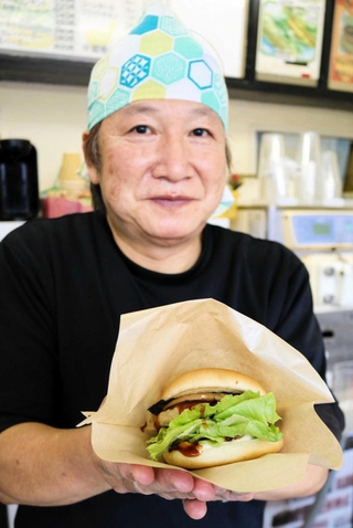 「とち餅本舗」とバーガーシティ代表の上坂晃太郎さんと、餅入りの「とちの実バーガー」＝豊岡市日高町日置