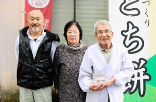「とち餅本舗」の（右から）上坂勇さん、幸子さん夫妻と、営業担当の佐藤稔さん＝豊岡市日高町荒川