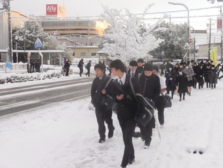 積雪の中を登校する高校生＝２３日午前、豊岡市高屋（撮影・大久保斉）