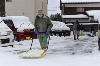 駐車場の雪かきをする地元住民＝２３日午前、兵庫県新温泉町浜坂（撮影・齋藤誉）