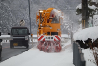 歩道の雪を取り除く除雪車＝新温泉町今岡