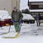 駐車場の雪かきをする地元住民＝２３日午前、兵庫県新温泉町浜坂（撮影・齋藤誉）