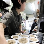 小皿に盛り付けられた出石そば。手際よく従業員が盛り付け、運んでいく＝豊岡市出石町小人