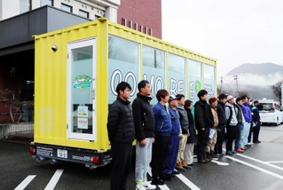 移動式ランドリー車と派遣する山本運輸の社員ら＝養父市八鹿町八鹿