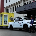 派遣する移動式ランドリー車と山本運輸の山本洋介社長＝養父市八鹿町八鹿