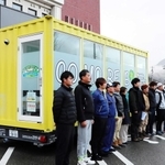 移動式ランドリー車と派遣する山本運輸の社員ら＝養父市八鹿町八鹿