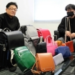 ランドセルから一点物のかばんに再生する事業を始めたかばんメーカー「コニー」の西田正樹社長（左）ら＝豊岡市佐野