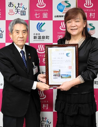 西村銀三町長（左）から特別観光大使の任命書を受け取るナレーターの木村匡也さん＝新温泉町役場