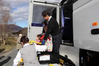 乗降機を使ってバスから降りる車いす利用者＝県立但馬牧場公園