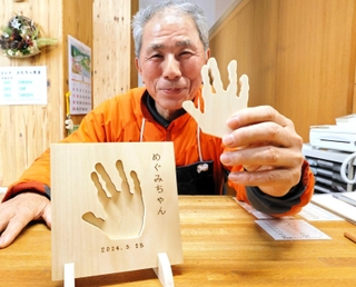 子どもの手形で作る盾をＰＲする木の殿堂の池田行夫副館長＝香美町村岡区和池