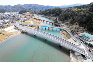 矢田橋（中央）を通る今のルートは橋の両端で急カーブを描くが、新しい矢田橋（手前）への架け替えで、カーブは緩やかになる。奥はＪＲ山陰線の矢田川橋梁（きょうりょう）＝香美町香住区矢田周辺（県新温泉土木事務所提供）