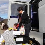 乗降機を使ってバスから降りる車いす利用者＝県立但馬牧場公園