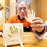 子どもの手形で作る盾をＰＲする木の殿堂の池田行夫副館長＝香美町村岡区和池