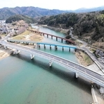 矢田橋（中央）を通る今のルートは橋の両端で急カーブを描くが、新しい矢田橋（手前）への架け替えで、カーブは緩やかになる。奥はＪＲ山陰線の矢田川橋梁（きょうりょう）＝香美町香住区矢田周辺（県新温泉土木事務所提供）