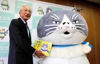 マルから絵本を受け取る広瀬栄養父市長＝養父市八鹿町八鹿