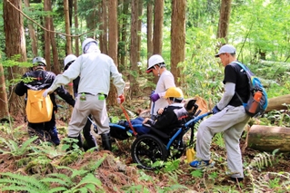 水陸両用のアウトドア車いすで森林を散策する河合美智子さん＝豊岡市日高町（全但バス但馬ドーム提供）