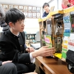 段ボールで作った全但バスの模型を、村上宣人社長（左）に説明する足立陸弥さん＝豊岡聴覚特別支援学校