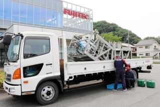 トラックにバイオディーゼル燃料を給油する業者のスタッフたち＝豊岡市日高町宵田