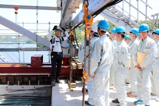 新しい橋の工事について説明を受ける篠山産業高校の生徒たち＝豊岡市城崎町楽々浦
