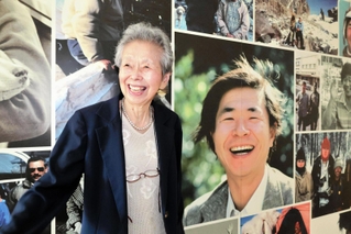 植村直己さんのパネル写真の前で満面の笑みを見せる妻公子さん＝豊岡市日高町、植村直己冒険館