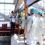 新しい橋の工事について説明を受ける篠山産業高校の生徒たち＝豊岡市城崎町楽々浦