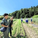 農作業を体験する中学生の近くで、小山収平さん（左）に話を聞く河合美智子さん＝豊岡市出石町
