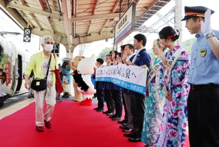 城崎温泉を訪れた観光客らを出迎える関係者ら＝豊岡市城崎町今津