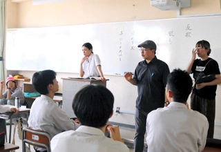 教材映像の収録で教壇に立つ二階堂ふみさんと、演技指導する深田晃司監督（右奥から２人目）ら＝豊岡総合高校