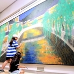 岩絵の具で色を付け足す子どもと、日本画家の山田毅さん（左）＝円山川公苑美術館